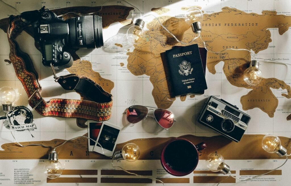 black DSLR camera near passport flat‑lay photo of a travel map, representing destinations and the solo journeys that shaped personal confidence