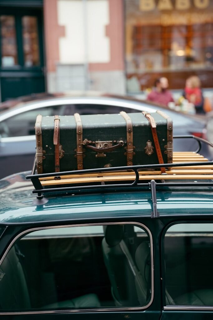 suitcase strapped to a car roof rack, symbolising road trips, freedom, and different solo travel styles for women